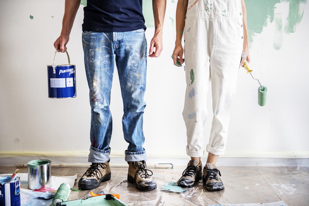Lower half of a couple doing DIY painting