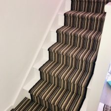 Earth stripe carpet fitted on stairs, 100% wool loop fitted over Cloud 9 Cirrus underlay with a black whipped edge runner to steps