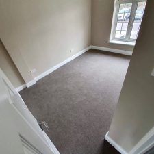 Grey wool twist carpet fitted in a bedroom by Sargeant Carpets