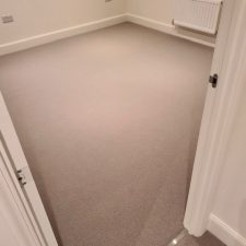 View of a bedroom fitted with light grey wool loop pile carpet by Sargeant Carpets.