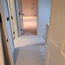 View through a hallway fitted with a carpet from the Rya range in pumice by Sargeant Carpets