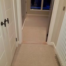 Beige colour carpet by Edel Telenzo Carpets from the London Bridge range fitted in a bedroom. A low level wool loop, 100% wool loop pile carpet.