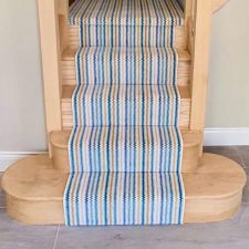 View of stairs with wooden edges and blue, white and beige stripy carpet runner by Adam Carpets' Panache range in Zing colour (code PN03)Adam-Carpets-Panache-range-Zing-PN03)