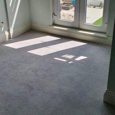 View of french doors in a bedroom fitted with a fine Worcester twist carpet by Adam Carpets in greystone glitter
