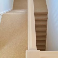 View down stairs with a beige carpet by Ulster Carpets from their Grange Wilton range in Spelt.