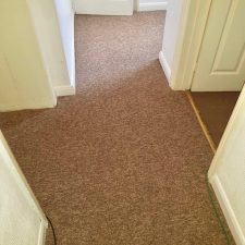 View of corridor floor fitted with beige polypropylene loop pile carpet from Bala's Gala Cord range in Wet Pebbles