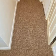 View of corridor fitted with beige polypropylene loop pile carpet from Bala's Gala Cord range in Wet Pebbles