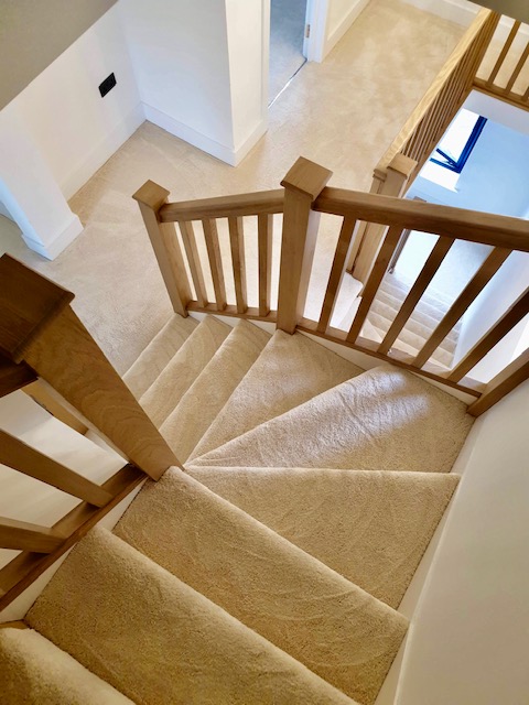 View down a flight of stairs fitted with thick polyester saxony pile carpet, in Somerset Ash from Cormar Carpets