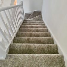 View down some stairs fitted with a Polypropylene heather effect twist pile carpet with easy clean bleach cleanable pile.