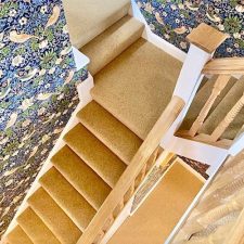 View of a flight of stairs fitted with a light brown woven Wilton carpet in 80% wool and 20% nylon pile. Extra heavy domestic quality, moth proofed.
