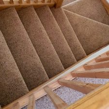 View down a flight of stairs fitted with a wool Berber Fleck twist pile carpet from Adam Carpets' Kasbah Twist range in Kazan