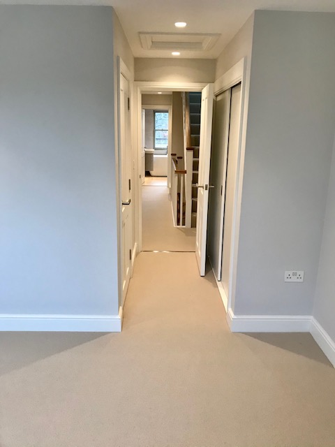 View out of a bedroom towards a landing fitted with a beige New Zealand wool loop carpet in premium quality two-fold yarn.