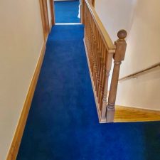 A landing and bedroom fitted with a blue 80% wool twist carpet by Victoria Carpets in Eclipse colour
