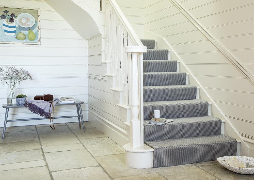 A bright staircase fitted with a striped carpet from the Avebury range in Stanton Stripe.