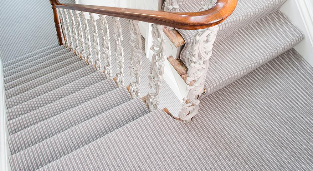 The Boucle Neutrals stripe carpet fitted on a flight of stairs