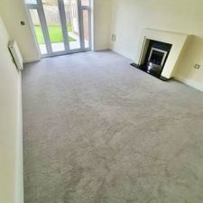 View of an empty lounge fitted with a polypropylene bleach-cleanable twist pile carpet in a grey shade called Pearl River