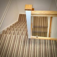 View down a flight of stairs fitted with a 3 ply British wool heavy domestic brown stripy carpet from the Hugh Mackay range.