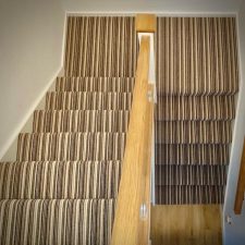 View down a flight of stairs fitted with a 3 ply British wool heavy domestic brown stripy carpet from the Hugh Mackay range.