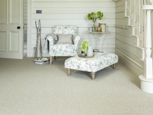 Living room with floral chair and footstool and a light neutral carpet from the Cormar Carpets Malabar range in Balm.