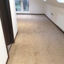 Room with a sloped ceiling and white walls fitted with a beige domestic polypropylene twist pile carpet.