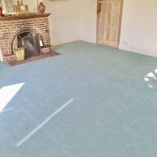 View of a living room with light grey wool/nylon twist moth proof carpet by Sargeant Carpets.