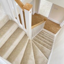 View down a flight of stairs fitted with a light grey polypropylene saxony carpet with a lovely soft pile.
