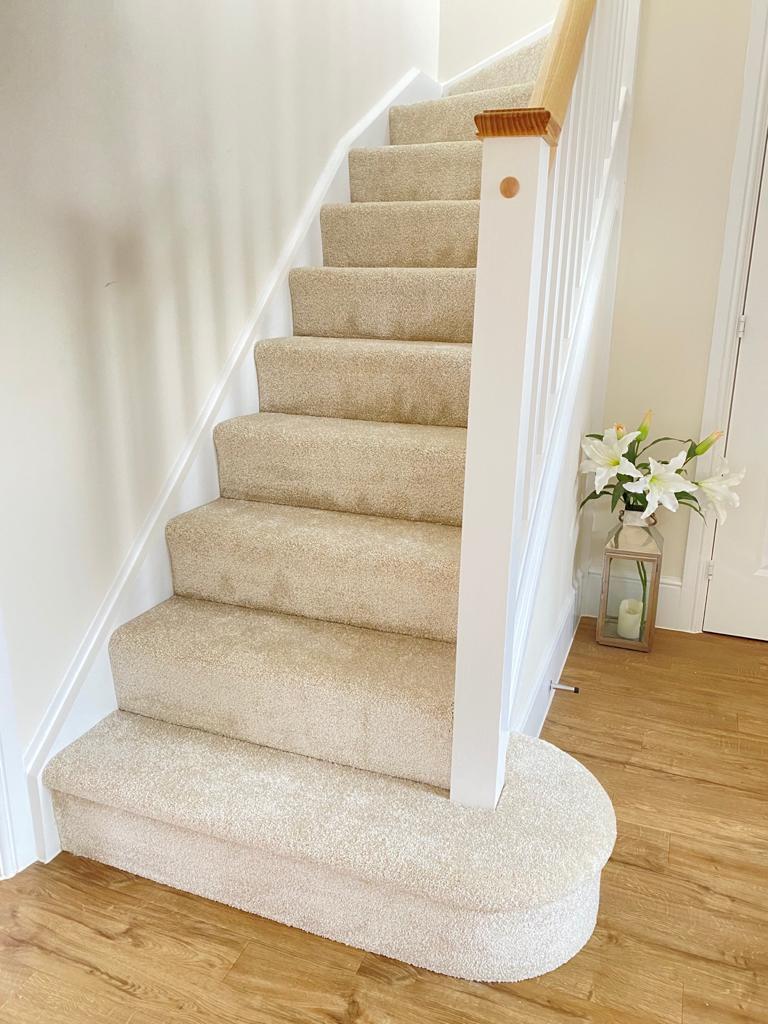 View up a flight of stairs fitted with a light grey polypropylene saxony carpet with a lovely soft pile.