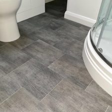 A bathroom floor fitted with grey heavy domestic, slip resistant vinyl floor tiles.