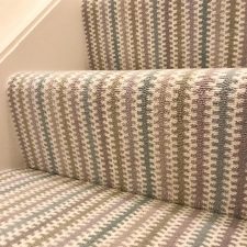 Of stair treads covered with a velvet tufted carpet by Adams Carpets in a neutral striped colour