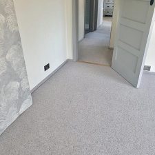 View of a bedroom fitted with a wool berber twist, moth resistant grey carpet.