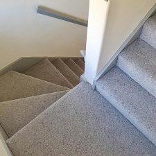 View down stairs fitted with a wool berber twist, moth resistant grey carpet.