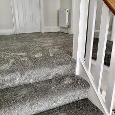 A grey landing and stairs fitted with a polypropylene twist, bleach cleanable carpet.