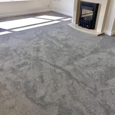 A lounge room fitted with a grey polypropylene saxony soft feel, bleach cleanable carpet.