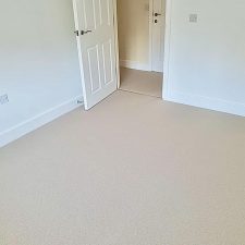 A bedroom floor fitted with a New Zealand wool loop carpet in a light beige colour.