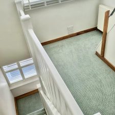 View down stairs and landing fitted with a duck egg coloured zigzag patterned carpet in 80% wool and 20% nylon