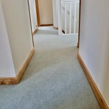 View of a landing fitted with a duck egg coloured zigzag patterned carpet in 80% wool and 20% nylon