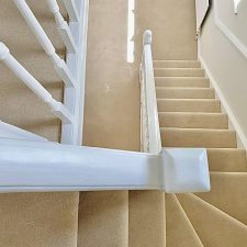 View down a flight of stairs fitted with a beige polypropylene twist carpet.