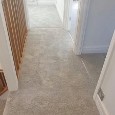 View of a landing and bedrooms fitted with a light grey Polypropylene saxony carpet.