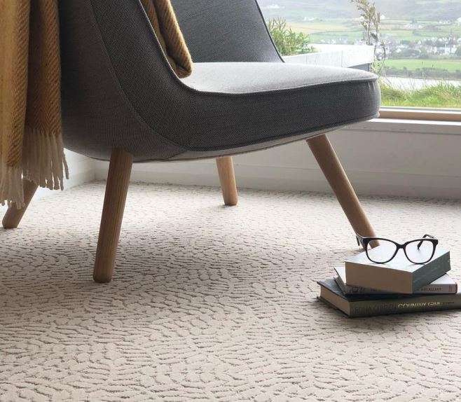 A living room carpet with a subtle leaf pattern