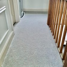 An landing fitted with a grey/green wool and nylon twist pile carpet.