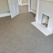 View of a bedroom with white fireplace, fitted with a neutral Wool mix berber twist, extra heavy domestic carpet.