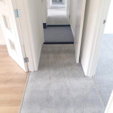 View of a landing fitted with white walls and woodwork, fitted with a grey polypropylene heavy domestic carpet.