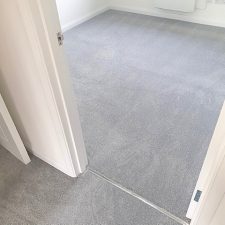 View into a bedroom with white walls and woodwork, fitted with a grey polypropylene heavy domestic carpet.