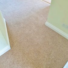 View of a hallway fitted with a neutral wool berber twist, moth resistant carpet.