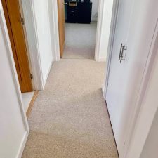 A hallway fitted with a beige wool berber twist carpet.