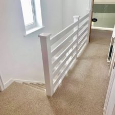 View of stairs and landing fitted with a neutral light brown moth resistant carpet.