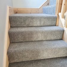 View up a staircase which is fitted with a grey heather twist, heavy domestic carpet.
