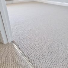 View into a living room fitted with a 100% New Zealand Wool light grey moth resistant carpet.