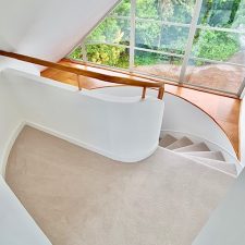 View down a spiral staircase fitted with a beige carpet by Victoria Carpets from their Tudor Twist range in cool ivory.