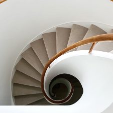 View down a spiral staircase fitted with a beige carpet by Victoria Carpets from their Tudor Twist range in cool ivory.